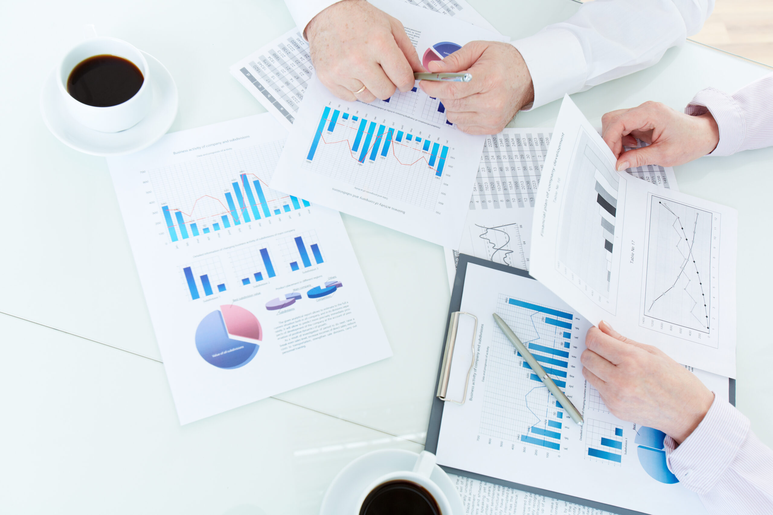 Above angle of mature business partners hands during discussion of papers